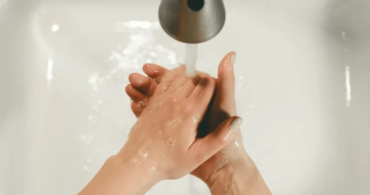 Seseorang mencuci tangan di wastafel.