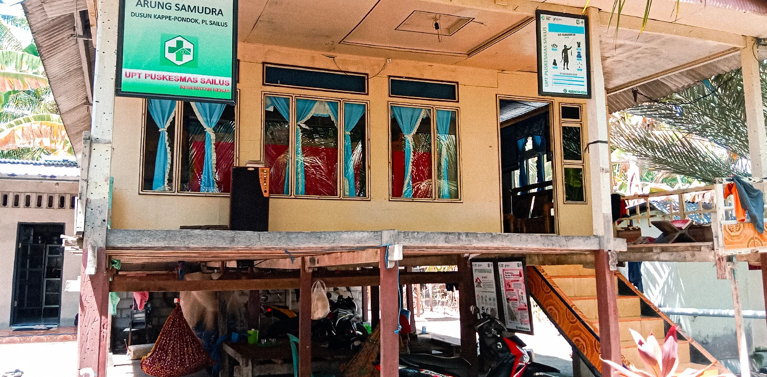 bangunan dengan pilar kayu dan tangga di sampingnya