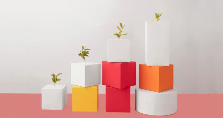 tumpukan kubus dan lingkaran dengan bibit pohon di atasnya