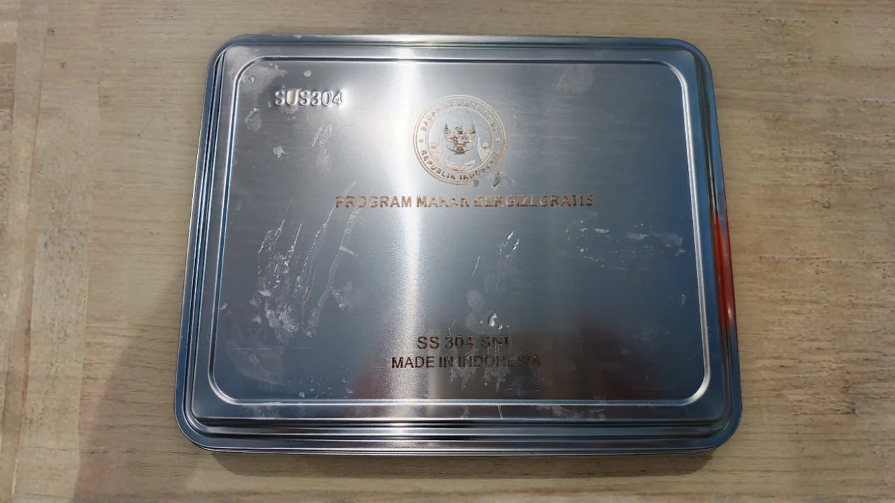 ompreng kaleng bertuliskan ‘program makan bergizi gratis’.