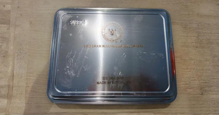 ompreng kaleng bertuliskan ‘program makan bergizi gratis’.