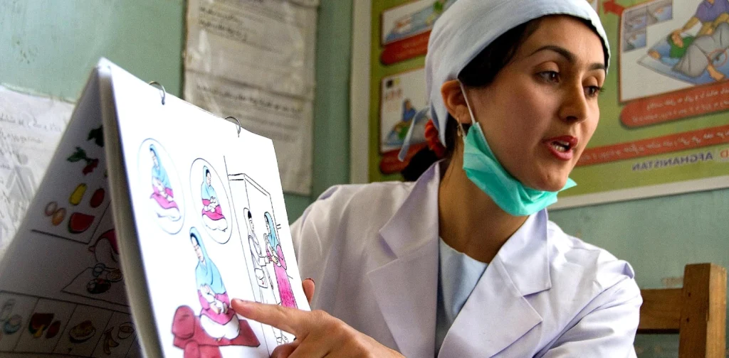 a midwife pointing at illustration of birth process