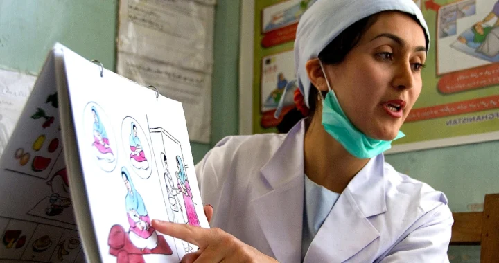 a midwife pointing at illustration of birth process