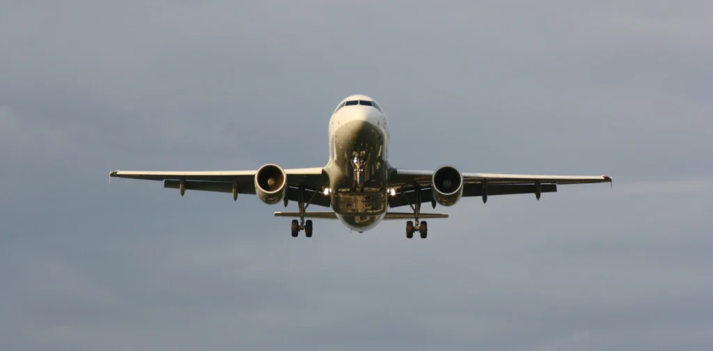 sebuah pesawat putih terbang melayang di udara