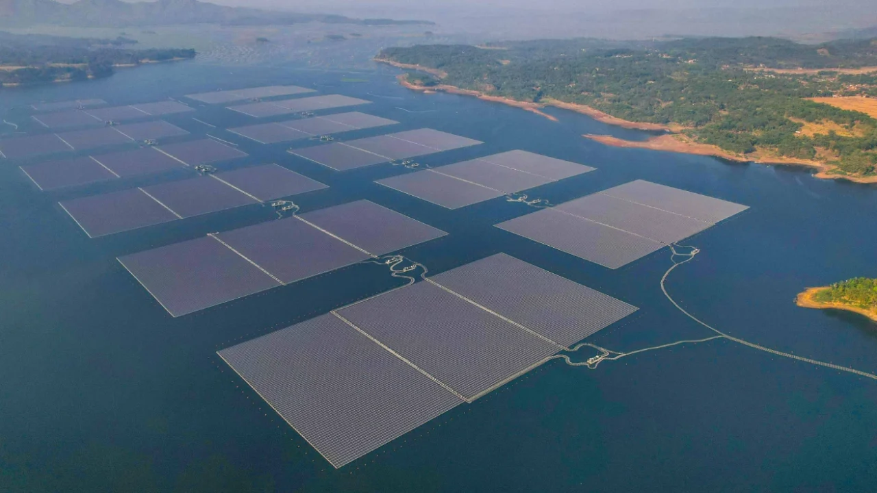 foto udara susunan panel surya di atas badan air di kelilingi oleh daratan