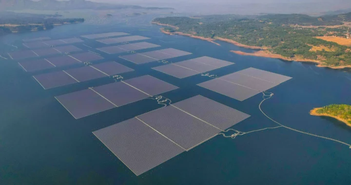 foto udara susunan panel surya di atas badan air di kelilingi oleh daratan