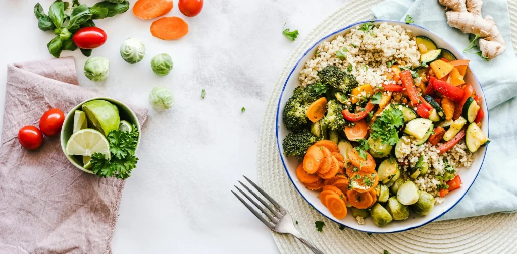sepiring salad buah dan sayuran di atas meja dengan beberapa potongan wortel dan tomat kecil di sekelilingnya