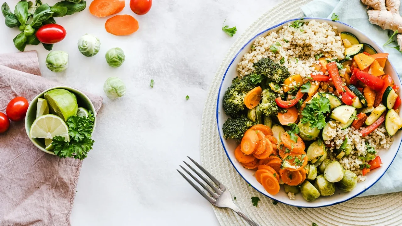 sepiring salad buah dan sayuran di atas meja dengan beberapa potongan wortel dan tomat kecil di sekelilingnya