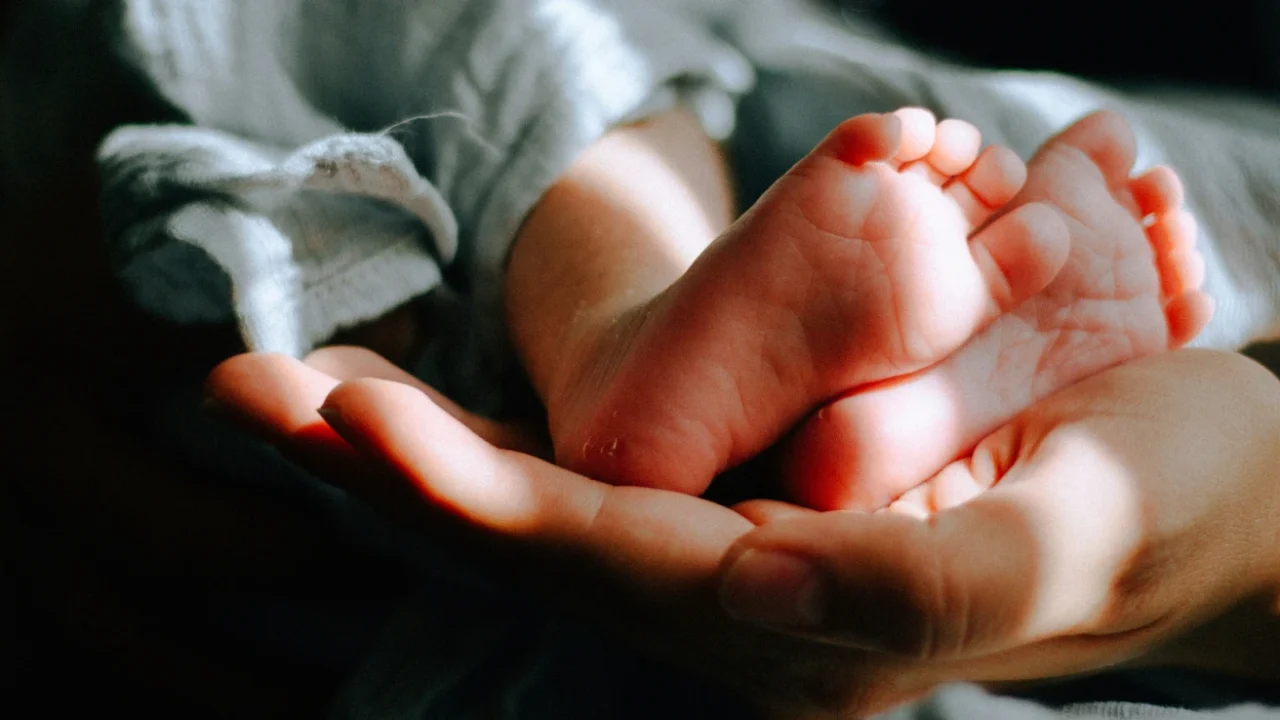 sebuah tangan menopang kaki bayi