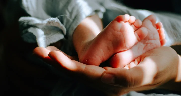 sebuah tangan menopang kaki bayi