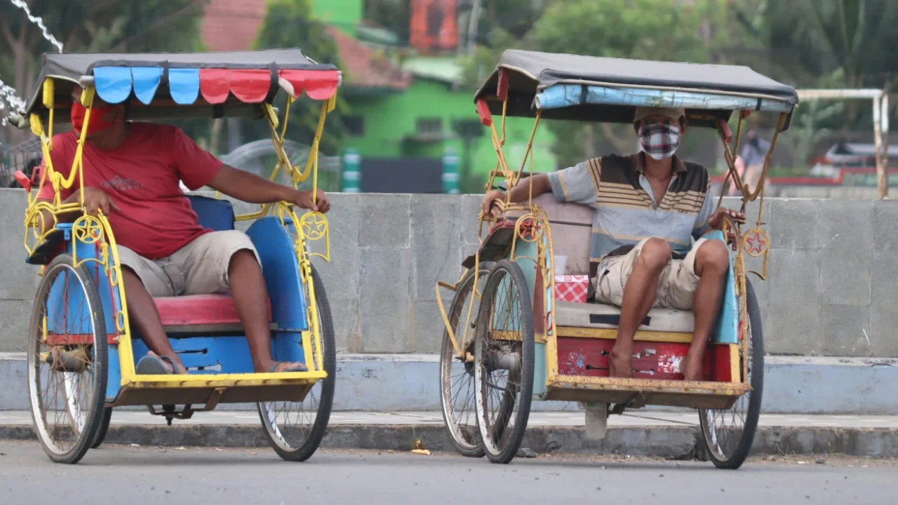 dua pria masing-masing duduk di atas becak sepeda.
