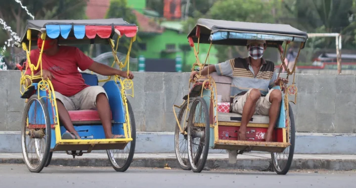 dua pria masing-masing duduk di atas becak sepeda.