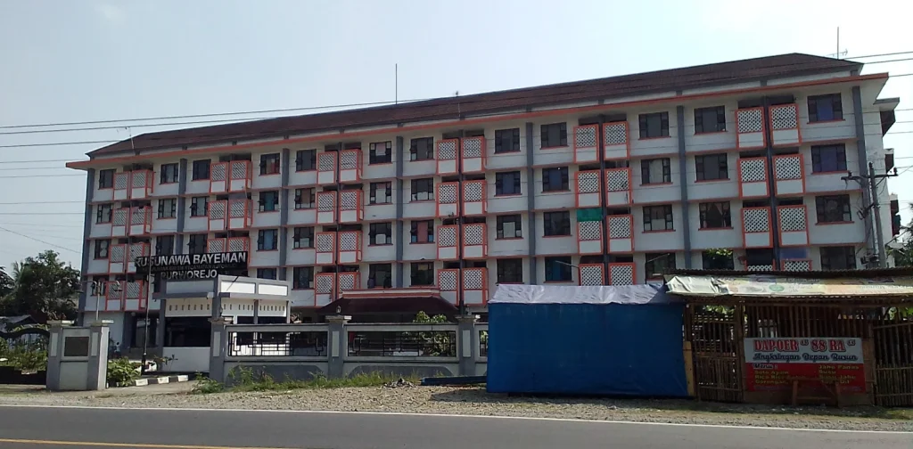 pos pemberhentian kereta api dengan latar bangunan bertingkat