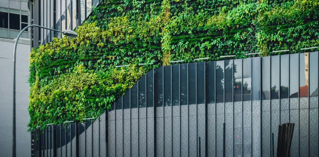 foto sebuah bangunan kaca yang ditutupi tanaman