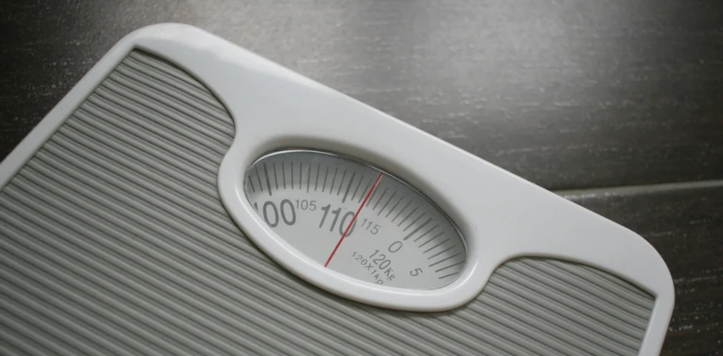 timbangan dengan jarum merah mengarah angka melewati 110 kilogram