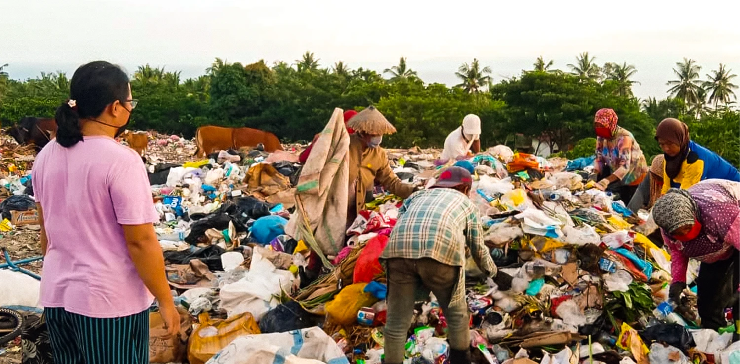 beberapa orang terlihat memilah sampah di tumpukan sampah