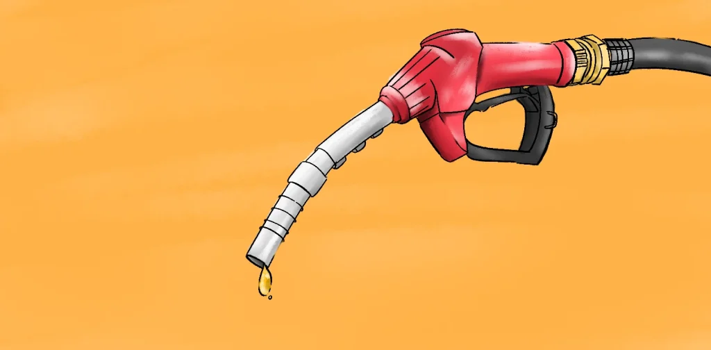 Nozzle pompa BBM berwarna merah dengan tetesan bahan bakar menetes dari ujungnya, berlatar belakang oranye.