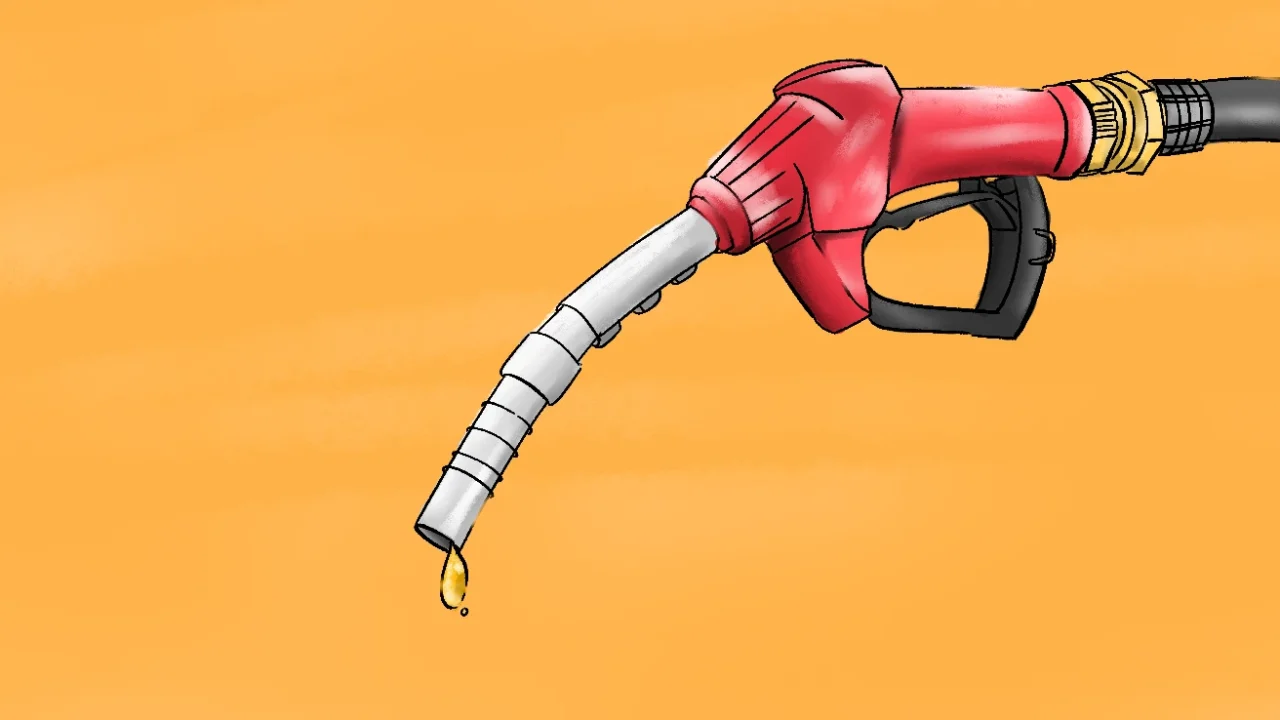 Nozzle pompa BBM berwarna merah dengan tetesan bahan bakar menetes dari ujungnya, berlatar belakang oranye.