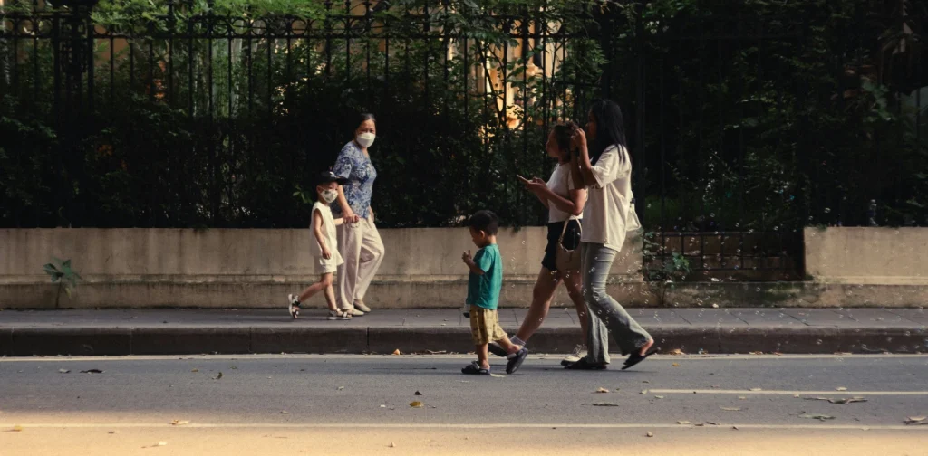 Dua kelompok keluarga dengan anak-anak berjalan berlawanan arah di jalan