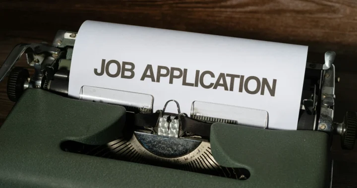 mesin tik dengan kertas putih bertuliskan ‘job application’