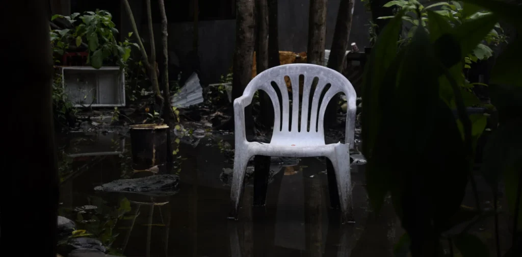 sebuah kursi plastik putih di taman yang tergenang air