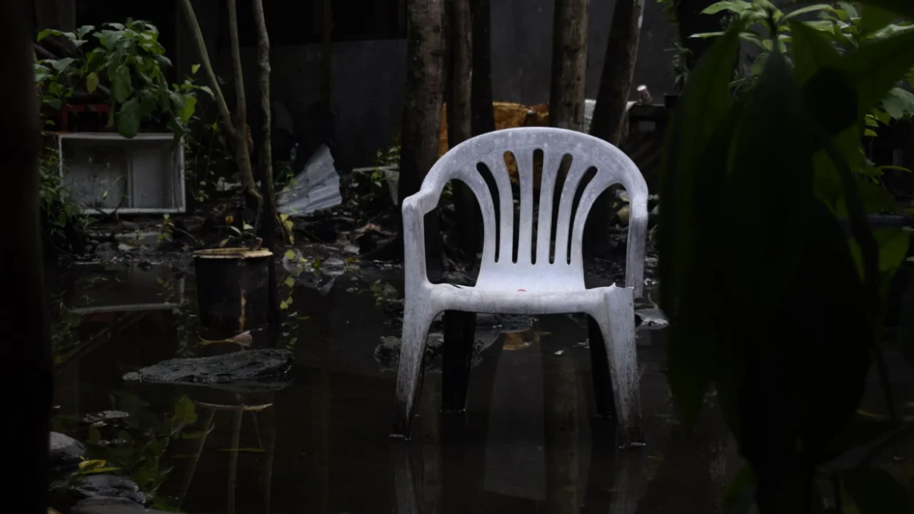 sebuah kursi plastik putih di taman yang tergenang air
