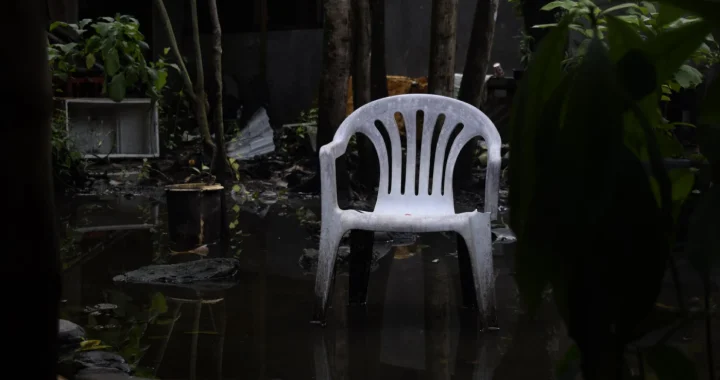sebuah kursi plastik putih di taman yang tergenang air