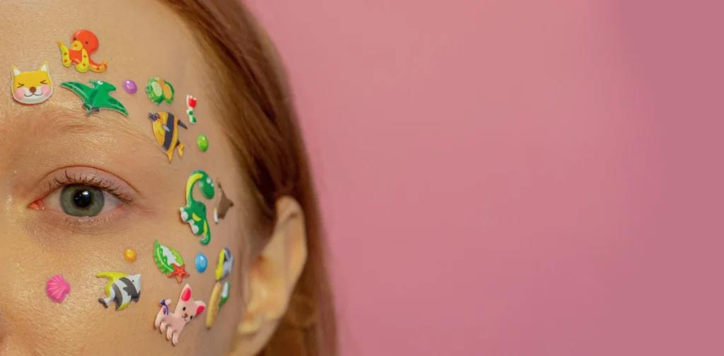 foto close-up separuh wajah seorang perempuan yang ditempeli stiker-stiker kecil